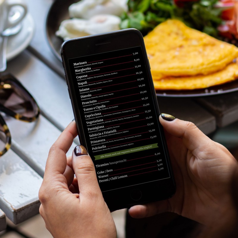 Two hands hold a smartphone displaying a digital menu.